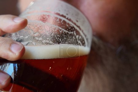 Foto de Un hombre bebiendo cerveza. Hombre con barba teniendo jarra de cerveza en el pub - Imagen libre de derechos