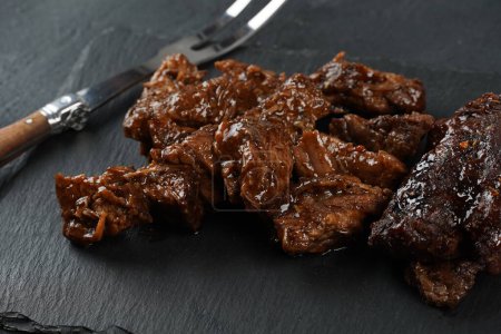Téléchargez les photos : Viande de bœuf en dés dans une sauce barbecue. Style rustique - en image libre de droit