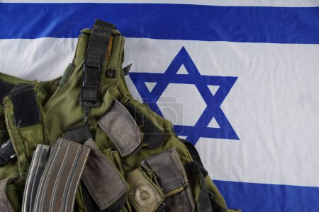 Téléchargez les photos : Gilet militaire. Des magazines de l'arme. Concept de l'armée. Le drapeau israélien comme arrière-plan. - en image libre de droit