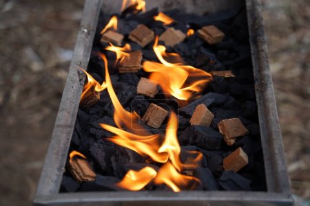 Téléchargez les photos : Barbecue vide grill flambant près avec des flammes vives et des allume-feux brûlant - en image libre de droit