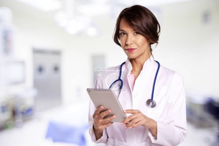 Foto de Retrato de una doctora sosteniendo su tableta digital mientras estaba de pie en el pasillo del hospital. - Imagen libre de derechos