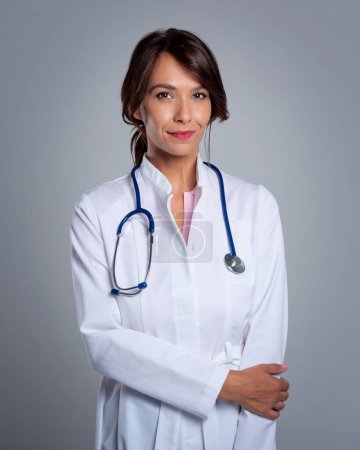 Photo for Portrait of female doctor with stethoscope. Close-up of healthcare worker is standing with arms crossed. She is against grey background. - Royalty Free Image
