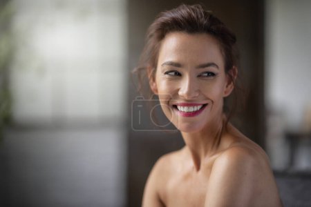Téléchargez les photos : Headshot d'une brune aux cheveux mi-âge femme joyeuse souriante et regardant loin à l'intérieur. - en image libre de droit