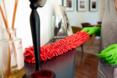 Photo for Close-up of a womans hand wiping the fireplace at home. Female using cleaning tool - Royalty Free Image
