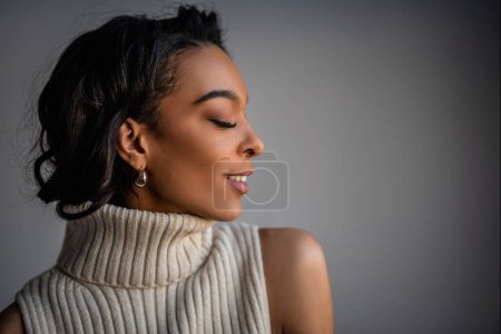 Téléchargez les photos : Gros plan d'un portrait de femme afro-américaine. Femme aux cheveux noirs sur fond gris. Espace de copie. - en image libre de droit