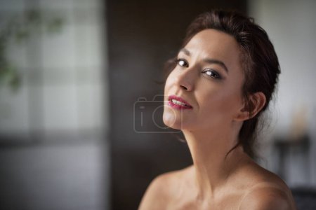 Téléchargez les photos : Headshot d'une brune aux cheveux mi-âge femme souriante et regardant la caméra. - en image libre de droit