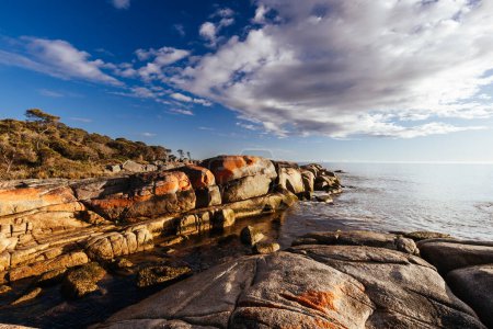 Foto de El icónico liquen cubría las rocas y el agua turquesa del océano en la Bahía de los Fuegos a través de Cosy Corner cerca de Binalong Bay, Tasmania, Australia - Imagen libre de derechos