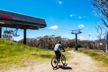 Photo for THREDBO, AUSTRALIA - DECEMBER 15 2023: Mountain bikers descend down Thredbo on a warm summers day in the Snowy Mountains, New South Wales, Australia - Royalty Free Image