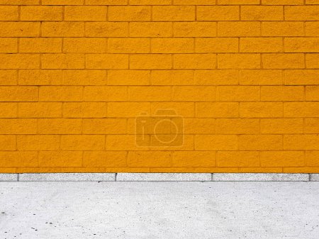Photo for Brick wall with regular shapes and a rough surface. Empty orange background facade building with sidewalk. - Royalty Free Image