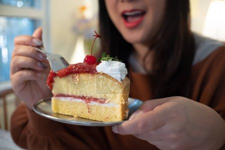 Frauen essen Kuchen zu Hause mit glücklichem Gesichtsausdruck