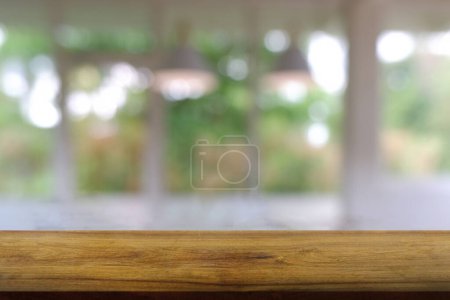 Table en bois vide devant un café abstrait flou, restaurant la nuit. Pour l'affichage du produit de montage ou de conception mise en page visuelle clé - Image