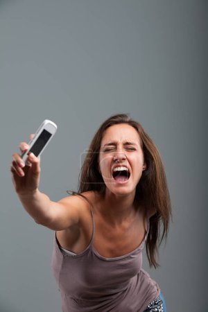 Athletically hurling her cellphone, the woman unleashes her anger-fueled violent strength, accompanied by a furious scream. She's completely fed up!