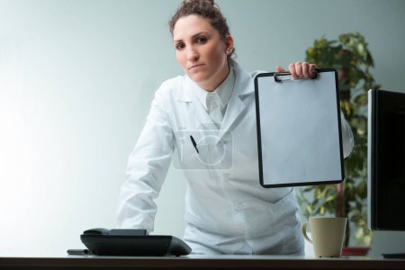 white-coated woman in an office animatedly gestures, mirroring the fervor in her facial expressions. Her tablet offers COPYSPACE. As a scientist or expert, she staunchly upholds her points, challengin
