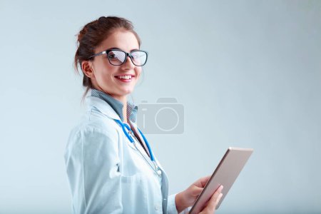 La investigadora en bata de laboratorio y gafas, sonriendo y mirando hacia arriba desde su tableta, proporciona claridad de hechos y orientación para las decisiones informadas