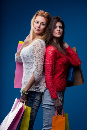 Retail therapy concludes with two women showcasing their bounty of shopping bags