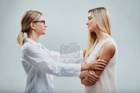Positive healthcare interaction captured as a doctor attentively examines a smiling, relaxed patient