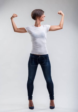 Woman exudes strength and positivity, showcasing her toned arms in a triumphant pose