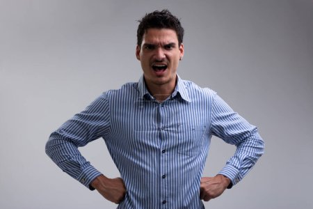 Mann in blau-weiß gestreiftem Hemd, wütend gestikulierend und große Missstände signalisierend. Wenn Ihr Verhalten anhält, wird er Ihnen eine Lektion erteilen