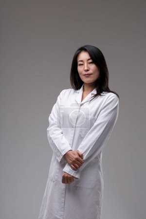 Serene medical practitioner in white, hands clasped, displays a calm confidence and ready expertise