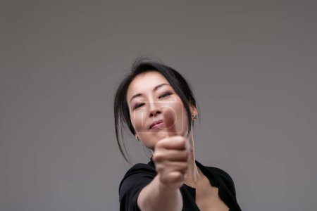 woman's confident thumbs-up conveys success, her composed demeanor adding to the affirmation