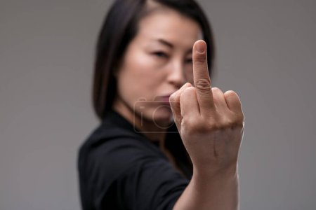 With a look of disdain, a woman of Japanese descent firmly rejects scams and tricks, her gesture expressing her tough stance