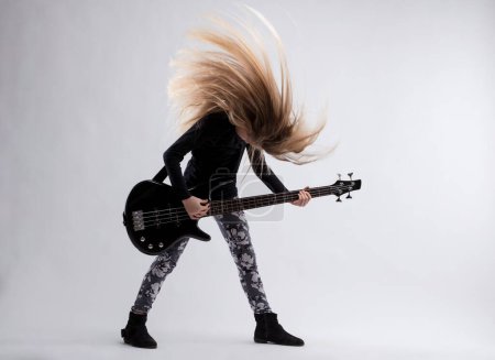 With a bass guitar in hand, the girl's intense hair wave speaks to her artistic drive
