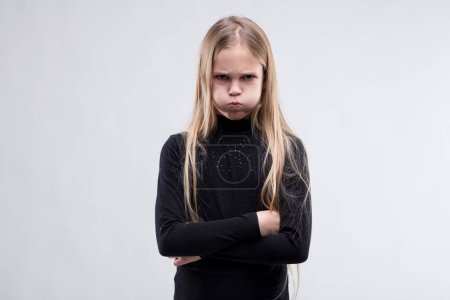 Child's pouting expression and defensive posture suggest a moment of dissatisfaction or stubborn resolve