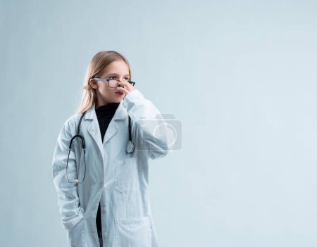 Das Mädchen, bekleidet mit Labormantel und Brille, zeigt ein starkes Interesse an der Wissenschaft