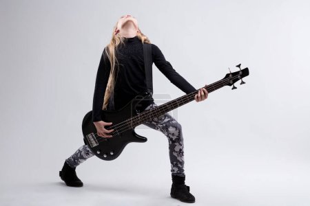 Girl in floral leggings rocks a bass, her posture and focus setting a creative scene
