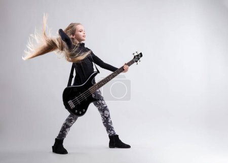 Child bass guitarist takes a bold stance, showcasing her skill and dedication to her craft 