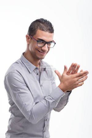 Un individu souriant en chemise argentée et lunettes rouges semble partager une remarque spirituelle