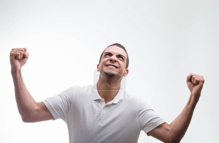 Man's victorious gesture and bright smile signify an exhilarating moment of accomplishment