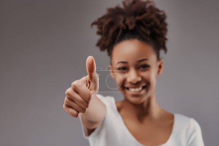 Cheerful and assured, her thumbs-up sign reflects a positive mindset and approachable character
