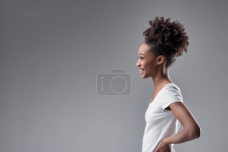 mirada lateral de la joven mujer emana confianza, con su peinado natural acentuando su carácter