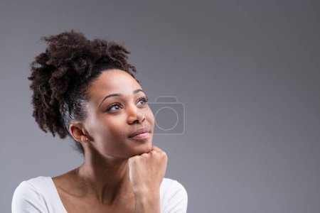 Mirada de ensueño y una pose reflexiva, el cabello de una mujer complementa su expresión esperanzadora