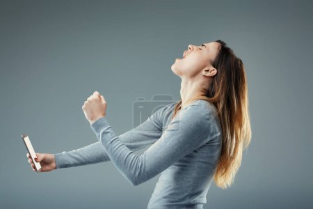 Ecstatic victory as woman punches the air, triumph written all over her exuberant face