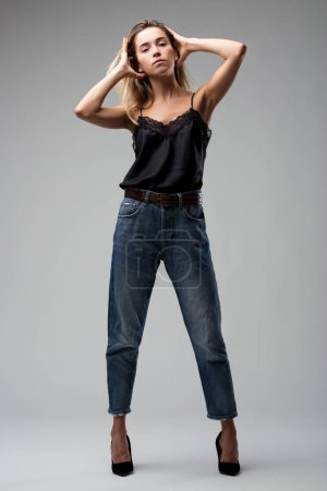 The woman's casual yet refined outfit, complete with a black lace top and jeans, portrays modern casual fashion