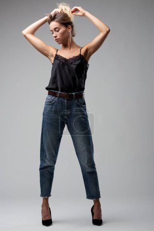 lässige Anmut einer gedankenverlorenen Frau, deren Kleidung feminine Spitze mit dem Rand von Jeans verschmilzt