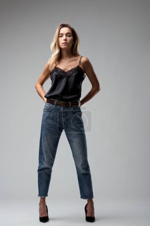 With hands confidently placed on her hips, she wears her lace top and jeans with a natural, unforced elegance