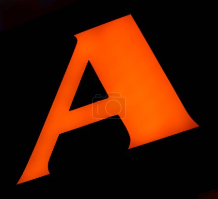leuchtend orangefarbenes "A" strahlt selbstbewusst gegen die Dunkelheit, seine Form perfekt und imposant