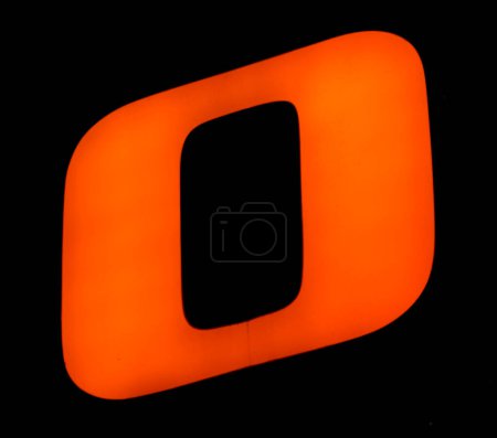 Illuminated orange 'O' in a deep void captures the essence of contemporary design and typography