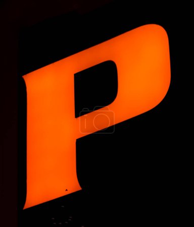 Leuchtend orangefarbener "P" -Buchstabe leuchtet lebhaft vor einem schattigen Hintergrund und verkapselt Kraft und Präsenz