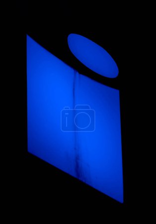 Leuchtendes "i" in elektrischem Blau, seine Einfachheit eine profunde Aussage in der Stille der Nacht