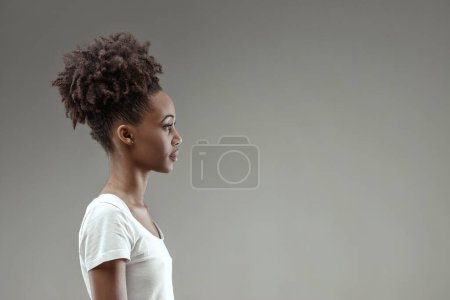 Profile of a young woman attentively listening, her expression focused and her posture poised