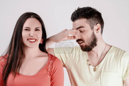 Homme et femme dans une pose épaule à épaule ; il a l'air mal à l'aise en raison de l'odeur de sueur d'elle