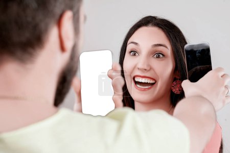 Energetisches Teilen digitaler Inhalte zwischen Mann und Frau, wobei Smartphone-Visuals zur Kommunikation anstelle von Wörtern verwendet werden