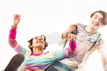 Exuberante pareja joven en pleno salto, sonriente y vestida de colores en una animada celebración