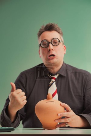 Geschäftsmann mit Brille wirbt optimistisch für einen zum Scheitern verurteilten Finanzplan und ermuntert irreführend zum Sparen in einem Sparschwein