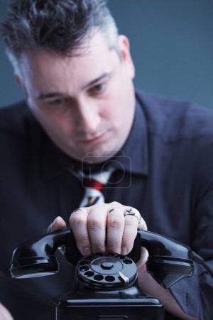 hombre en profunda concentración maneja una llamada telefónica desafiante con una expresión seria y determinada