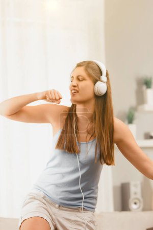 In a moment of pure joy, the woman dances to her music, the headphones amplifying the rhythmic experience and pretend singing